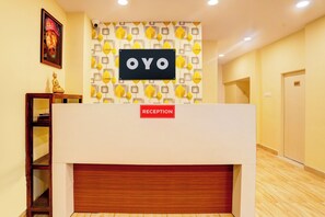 Un mostrador de recepción con un cartel que dice 'OYO' y una etiqueta que indica 'RECEPCIÓN'.