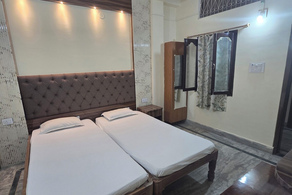 A bedroom with a double bed, a wooden headboard, a ceiling fan, and a nightstand.