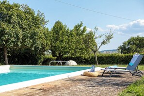 A swimming pool with a clear blue water, surrounded by lush greenery and trees. - Nice apartment for 10 guests with WIFI, pool, terrace and panoramic view (San Venanzo)