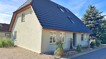 Einbungalow mit geneigtem Dach, einem Fenster und einer kleinen Veranda.