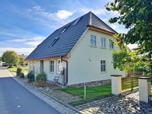 A single-story house with a sloped roof, a front porch, and a paved driveway. - Vrbo Property (Polchow)