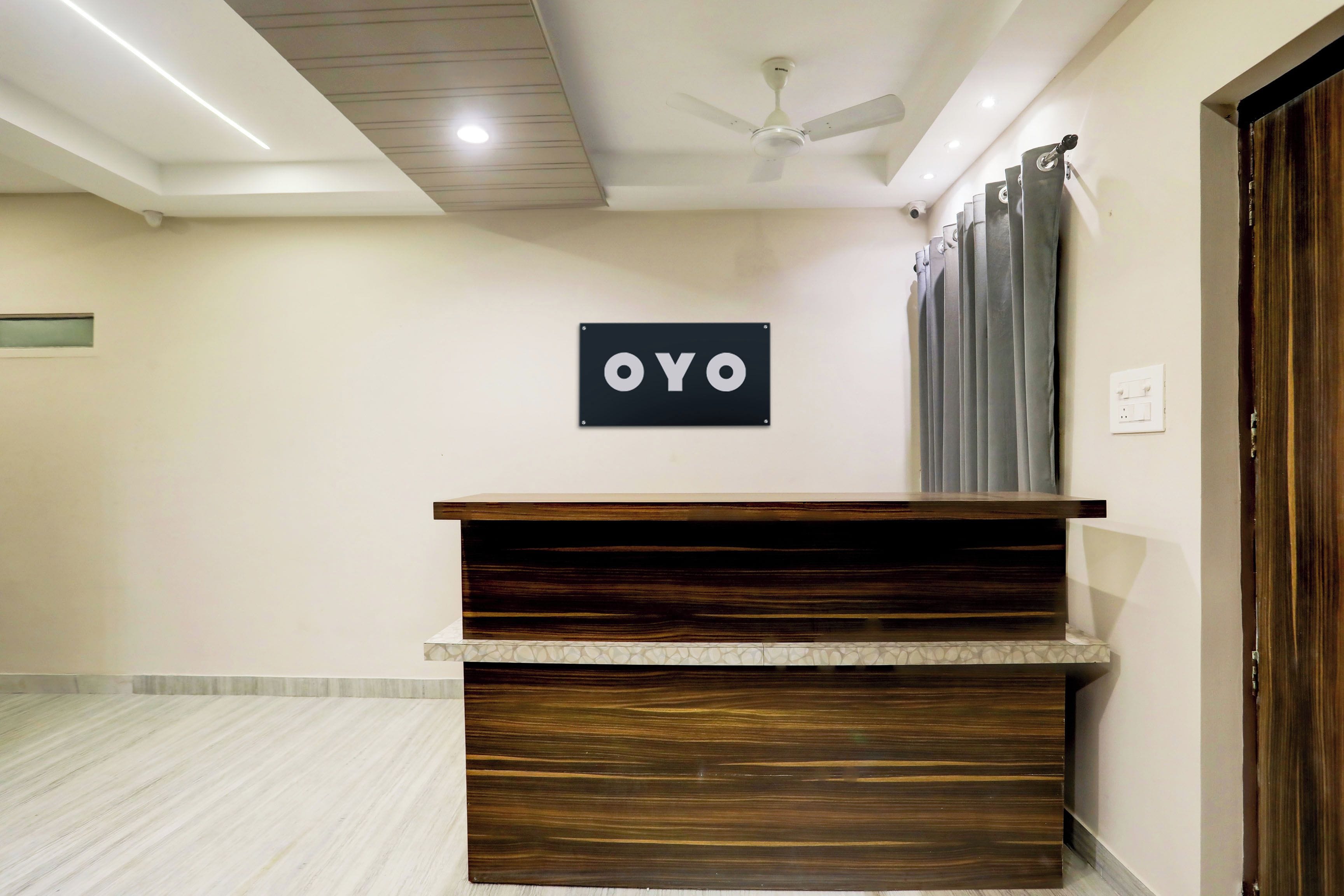 En receptionsdisk med en skylt som visar texten ”OYO” i en hotellobby.