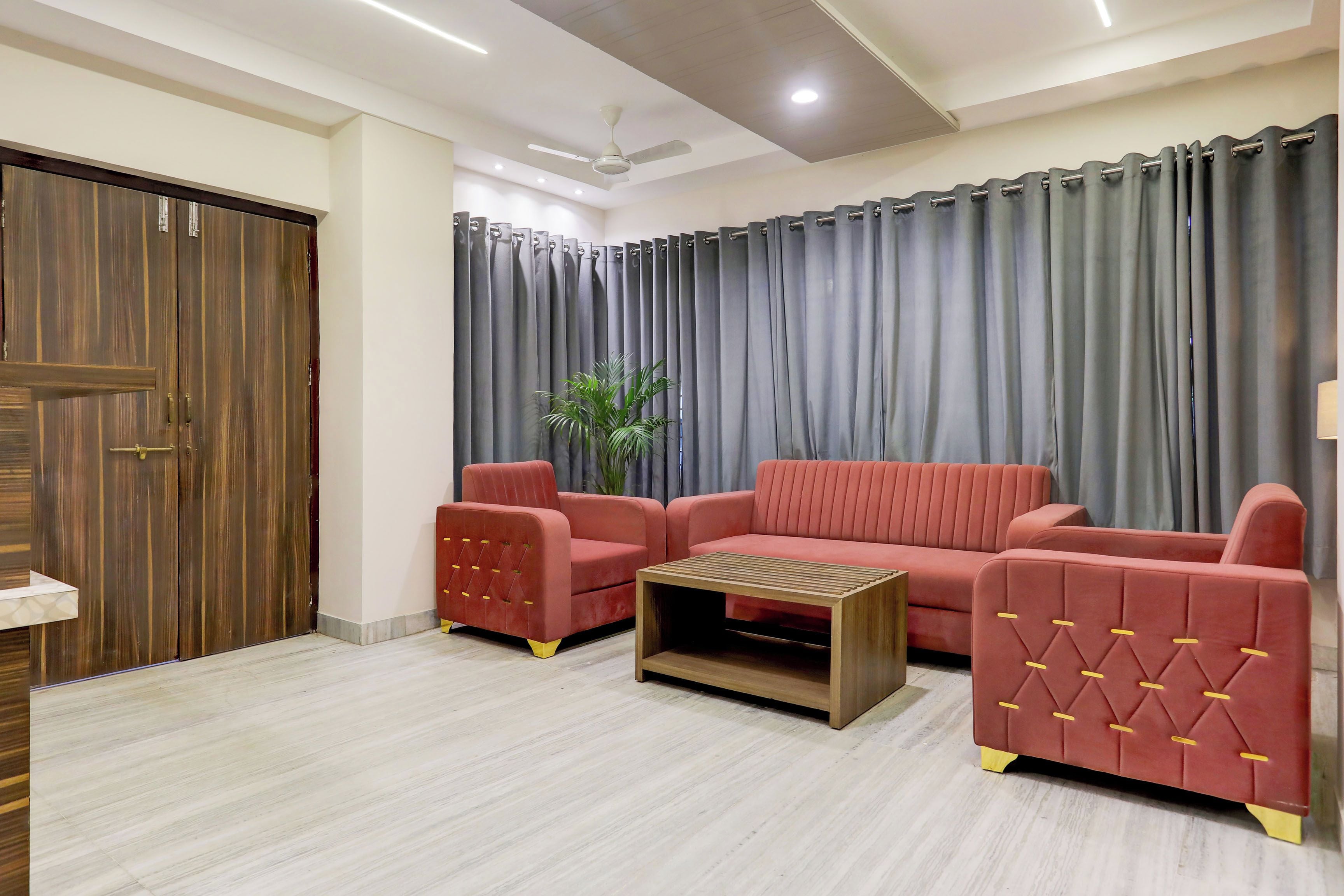 A living room with a sofa set, a coffee table, and a wooden door.