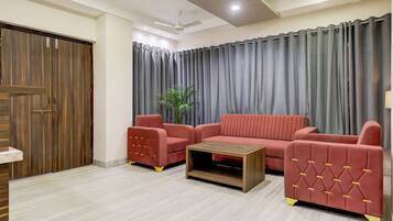 Una sala de estar con un conjunto de sofá, una mesa de centro y una puerta de madera.