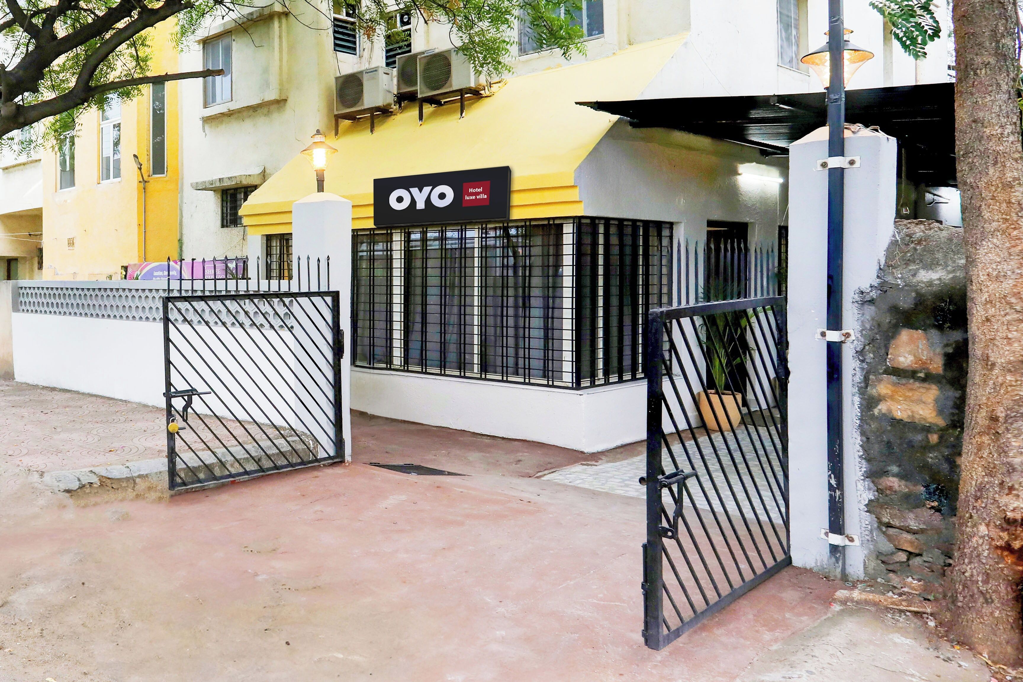 A gated entrance to a hotel with a sign indicating it is a 'OYO Hotel'.