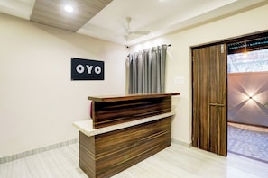 Una mesa de recepción con un letrero que dice 'OYO' en el vestíbulo de un hotel.