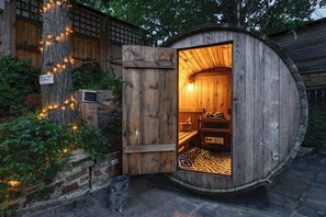 A wooden structure with a door, a bench, and a patterned rug inside. - The Ridge London | Luxury Home (Belvedere)