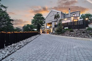 A modern two-story house with a paved driveway and a landscaped garden. - The Ridge London | Luxury Home (Belvedere)