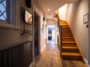 A hallway with a wooden staircase leading to an upper floor. - The Ridge London | Luxury Home (Belvedere)