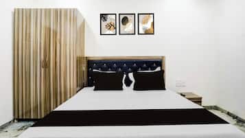 Un dormitorio con una cama, un armario y tres obras de arte enmarcadas en la pared.