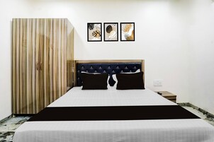 Un dormitorio con una cama, un armario y tres obras de arte enmarcadas en la pared.
