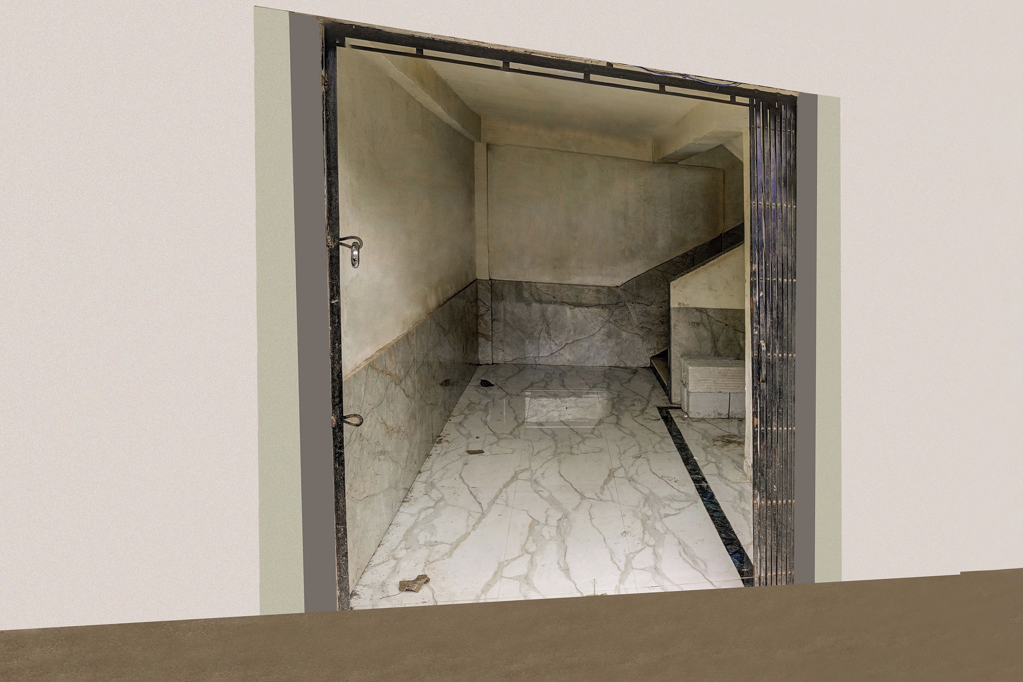 A hallway with a marble floor leading to a staircase.