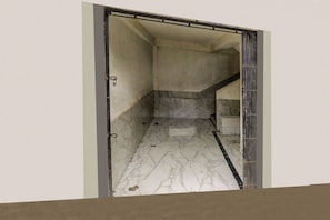 Een gang met een marmeren vloer die leidt naar een trap.