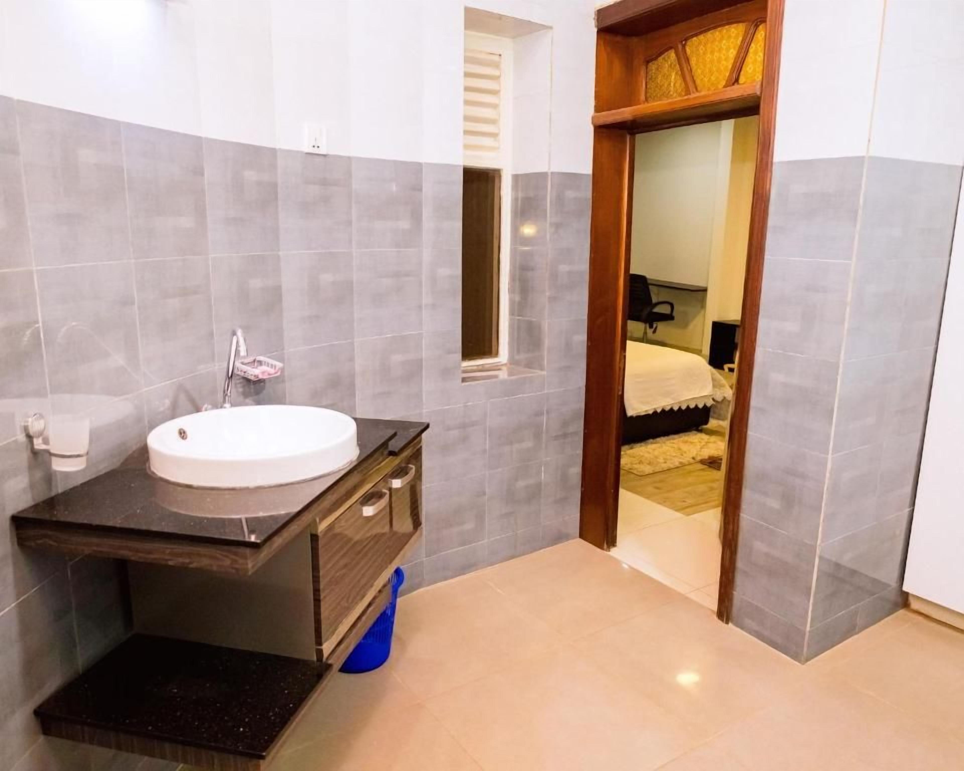 Un baño con lavamanos, espejo y zona de ducha.