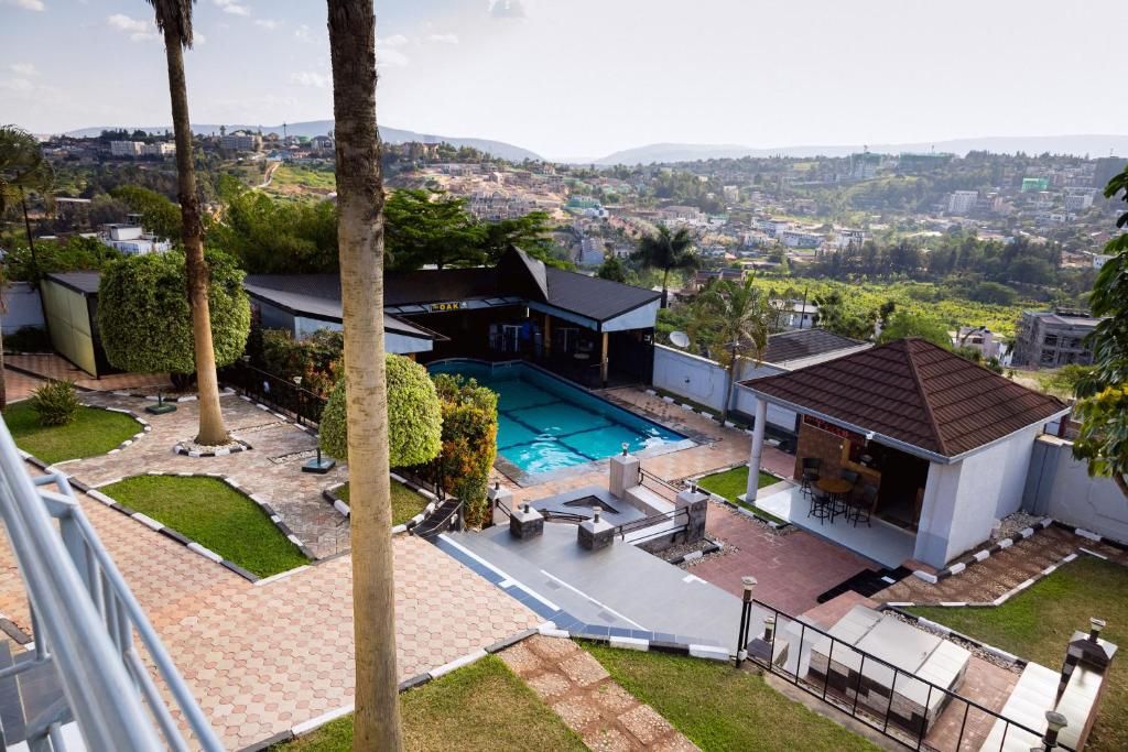 Propiedad residencial con piscina, zona de estar exterior y vistas a un paisaje urbano.