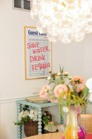 Una mesa con un cartel que dice 'Ahorra agua, bebe tequila' y una decoración de mesa con flores y una botella.