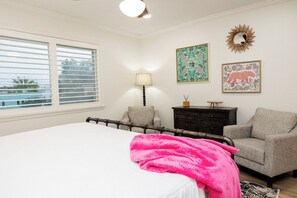 Un dormitorio con cama, una silla, una mesita de noche y una ventana con persianas.