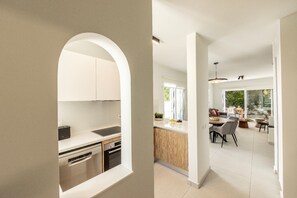 A modern kitchen with stainless steel appliances and a dining area with a large window. - 3 Bedroom Villa In The Heart of Protaras (Paralimni)