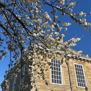 A building with two windows and a clear blue sky. - Grendon Hall Estate (Grendon)