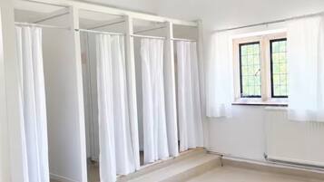Una habitación con un ventanal grande, un armario empotrado con varias puertas y un piso cubierto de alfombra.