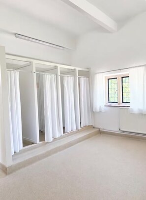 A room with a large window, a built-in wardrobe with multiple doors, and a plain carpeted floor. - Grendon Hall Estate (Grendon)