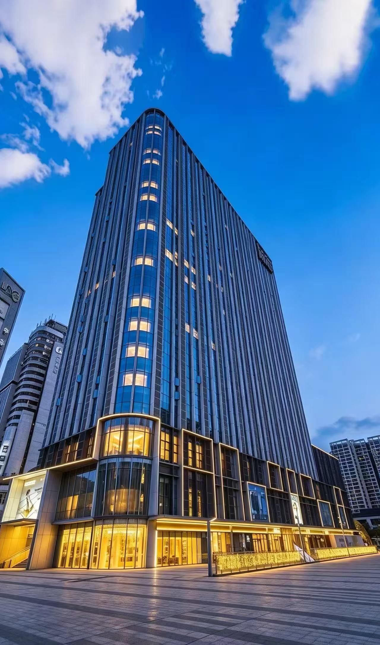 A modern high-rise building with a prominent glass facade and a curved lower section.