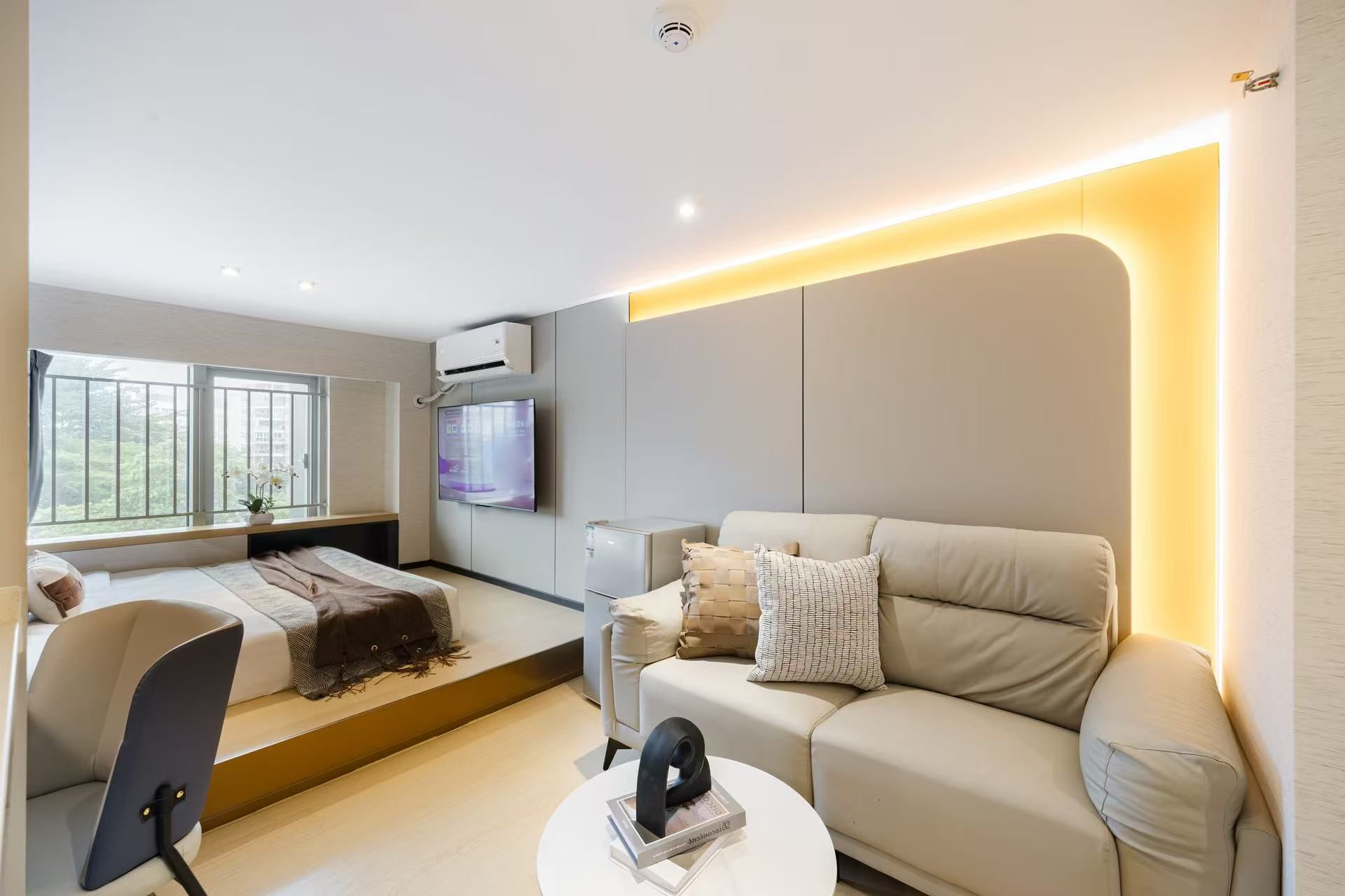 A modern living room with a sofa, a coffee table, and a TV.