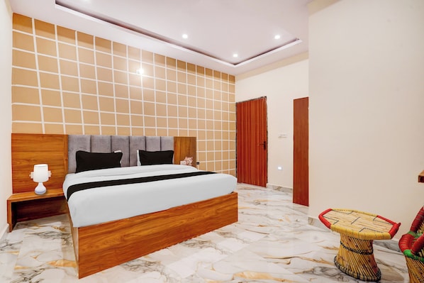 A modern bedroom with a large bed, wooden headboard, and a marble floor. - Collection O Radha Krishna Vrindavan (Vrindavan)