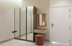 A modern bathroom with a glass shower enclosure, a wooden vanity, and a round stool. - Wonderful 3-bedroom apartment with AC in vibrant riyadh (الرياض)