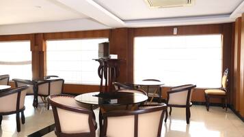 Una habitación de hotel con un ventanal grande, una mesa redonda y varias sillas.