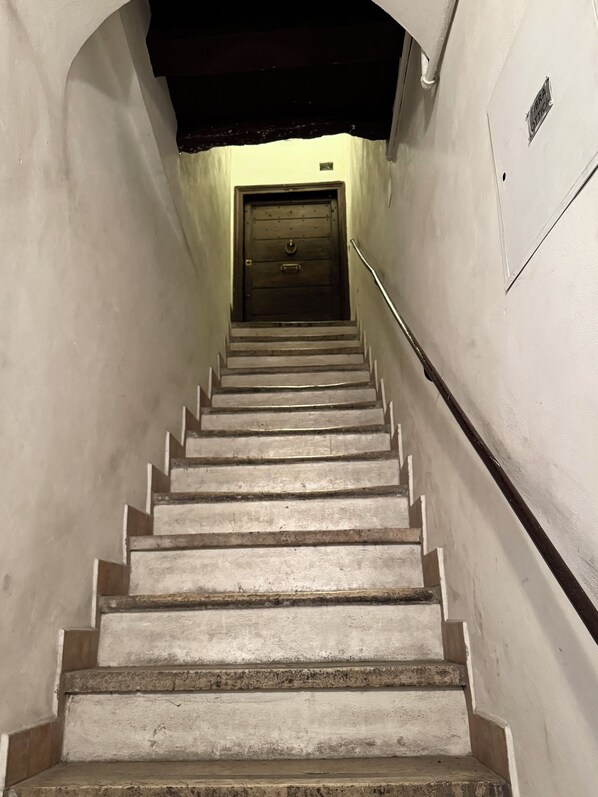 A staircase leading to a door with a sign above it. - Vrbo Property (Roma)