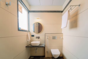 A compact bathroom with a sink, mirror, and toilet. - Shri Kalyan Hotel And Restaurant Khatu (Khatoo)