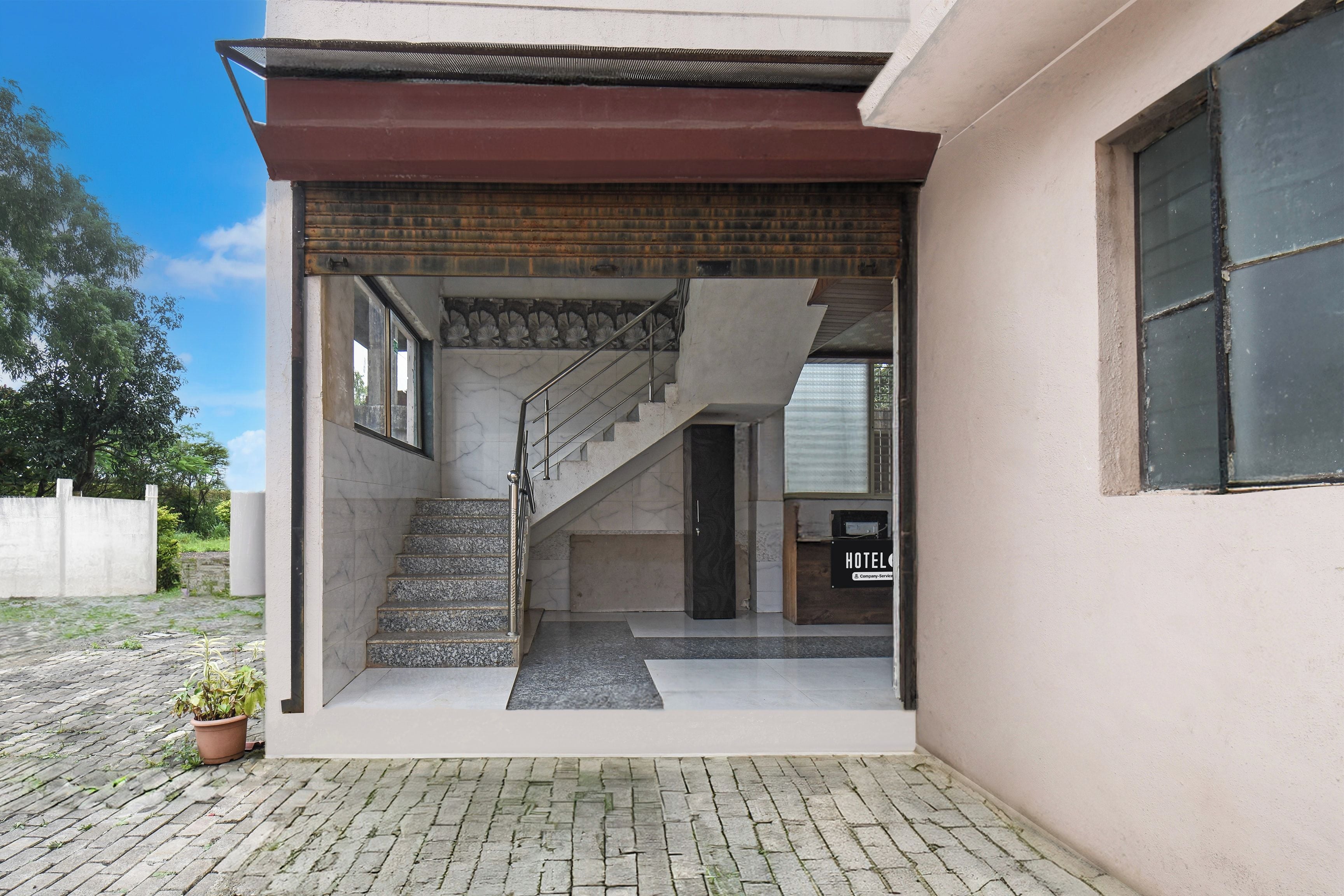 A hotel entrance with a staircase leading to the interior.