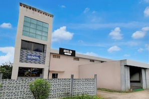 A modern hotel building with a sign indicating it is a company-serviced hotel.
