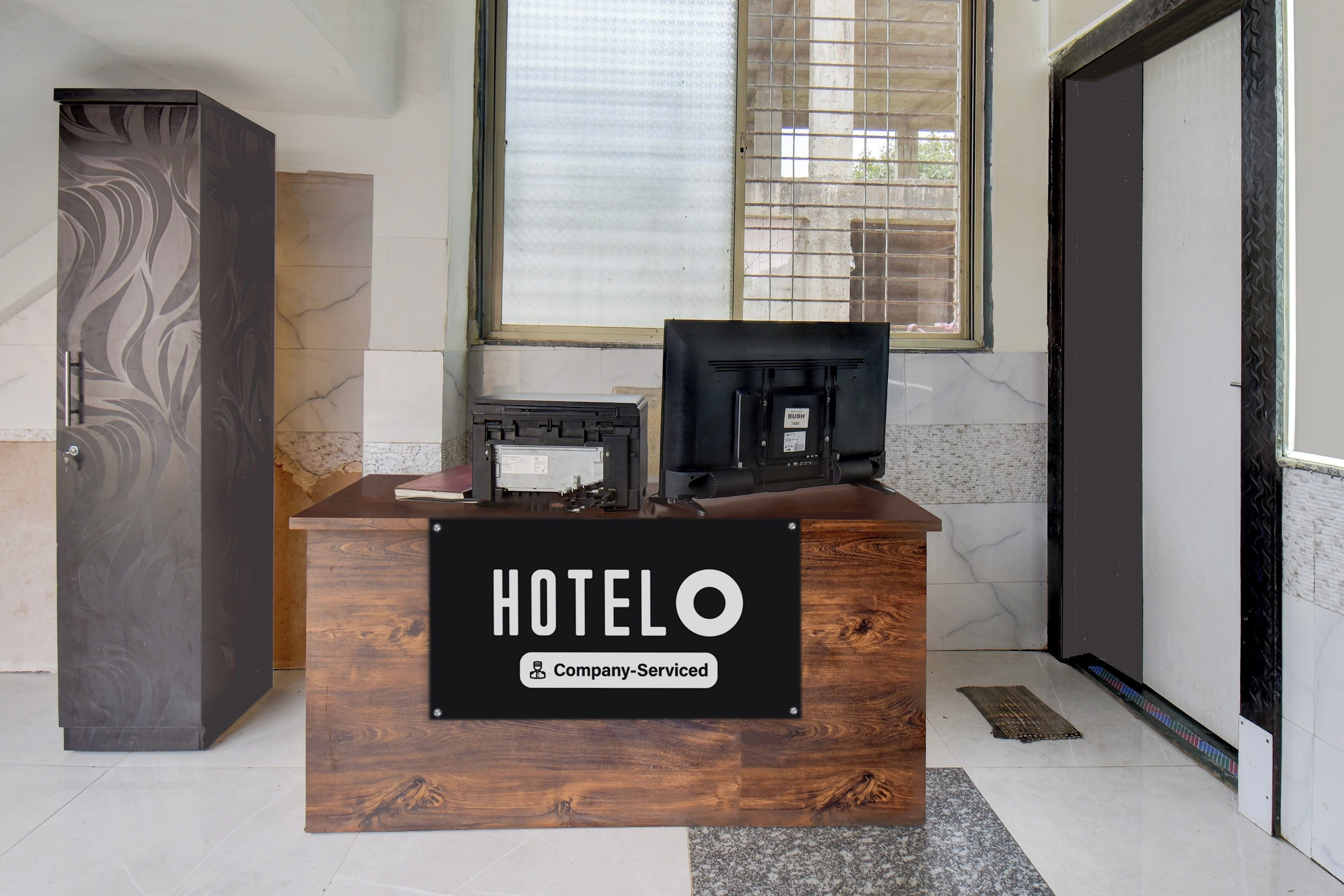 A reception desk with a sign reading 'HOTEL' and 'Company-Serviced'.