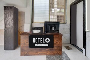 A reception desk with a sign reading 'HOTEL' and 'Company-Serviced'.