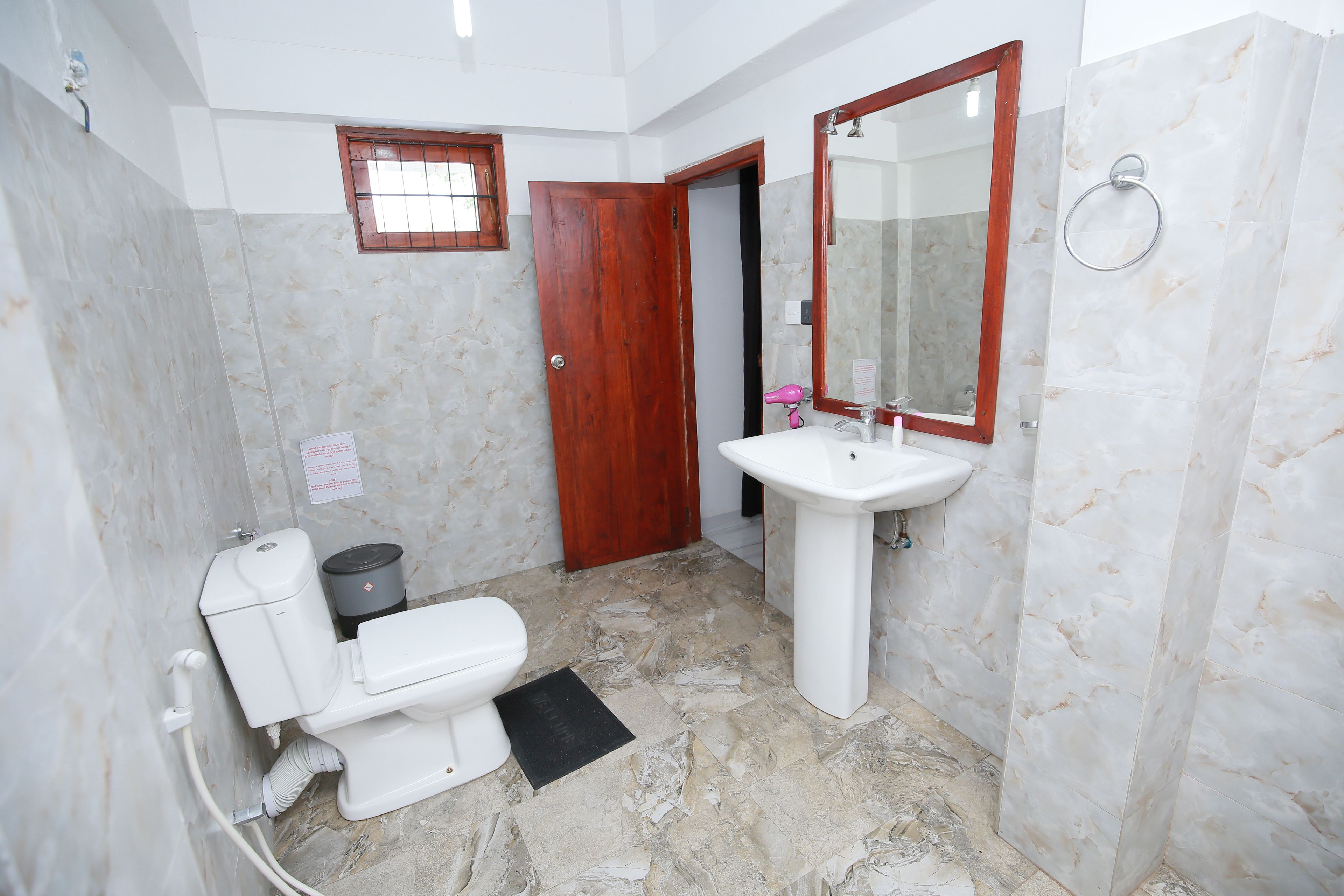 Un baño con inodoro, lavamanos y espejo.