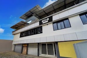 A modern building with a flat roof, large windows, and a sign that reads 'HOTEL'. - Hotel O Erumeli Kottayam Pious B (Kottayam)