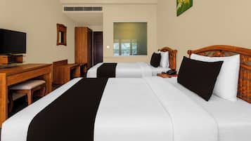 A hotel room with two beds, a desk, a television, and a window.