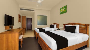 Ein Hotelzimmer mit Bett, Schreibtisch, Fernseher und Kunstwerken.
