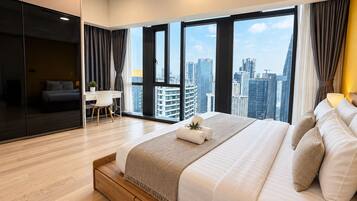 A modern hotel room with a large bed, a desk, and a view of the cityscape.