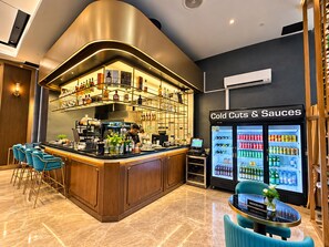 A bar area with a curved counter, seating, and a refrigerated display of cold cuts and sauces. - Star Residences KLCC -Royale Stay (Kuala Lumpur)