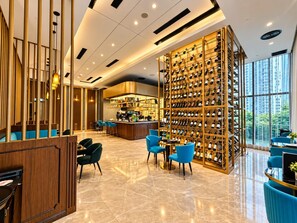 A modern hotel lobby with a wine rack, seating area, and a bar. - Star Residences KLCC -Royale Stay (Kuala Lumpur)