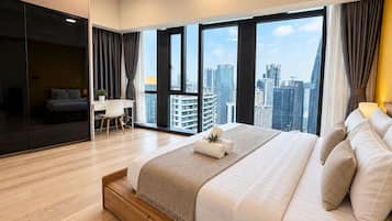 A modern hotel room with a large bed, a desk, and a view of the cityscape.