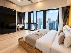 A modern hotel room with a large bed, a desk, and a view of the cityscape.