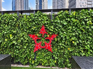 A wall with a green leafy backdrop and a red circular pattern.