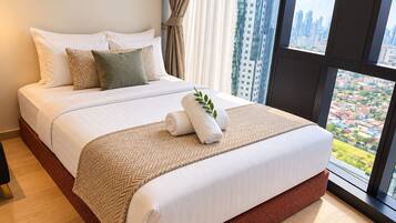 Habitación de hotel con una cama grande, vistas a la ciudad y una ventana con cortinas.