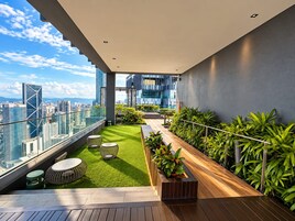 Terraza en la azotea con vistas al horizonte urbano, césped verde y zona de estar.