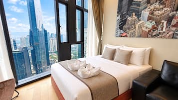 A hotel room with a large bed, a city view, a black leather chair, and a painting on the wall.