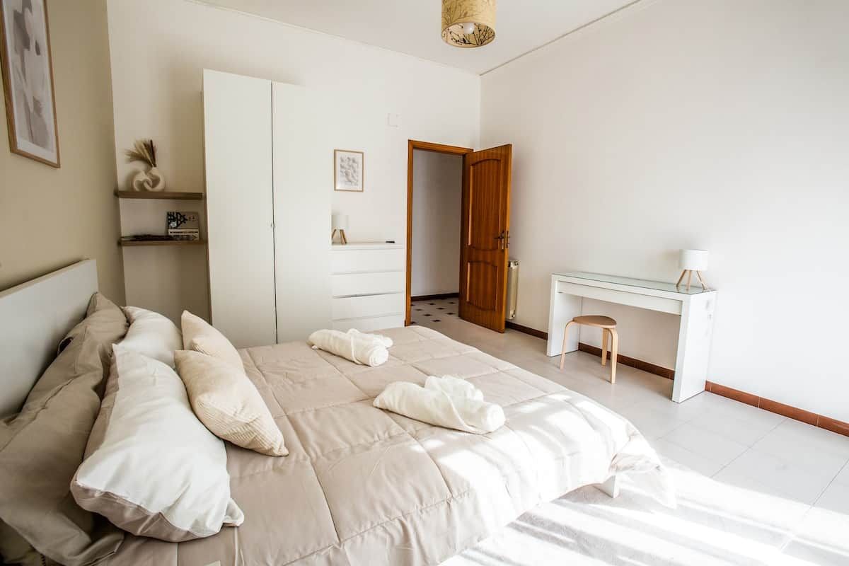 Een slaapkamer met een bed, bureau en kledingkast.